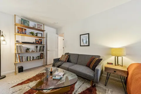 a living room with furniture and painting on the wall