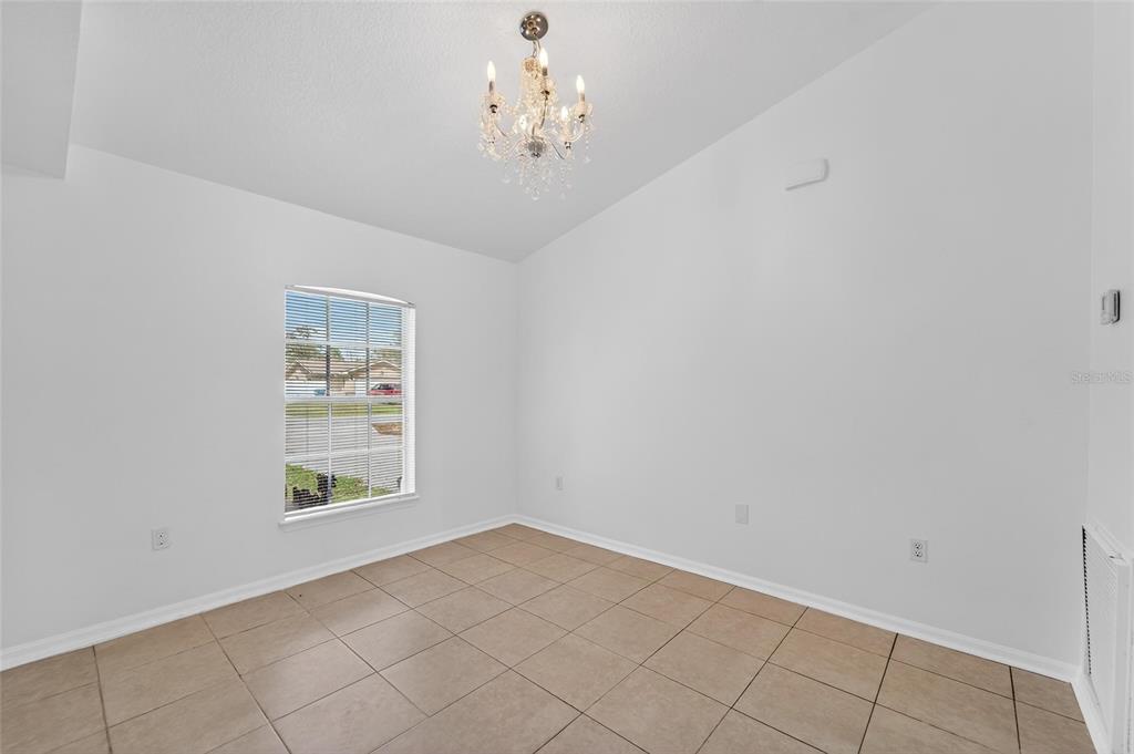 9010 Mc Cormick Street Spring Hill, FL 34608 - Photo 15 of 73 an empty room with windows and chandelier fan