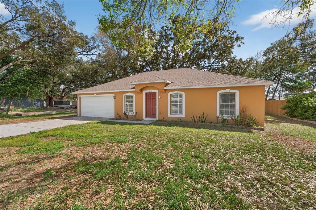 9010 Mc Cormick Street Spring Hill, FL 34608 - Photo 2 of 73 a view of a yard in front of a house with large trees