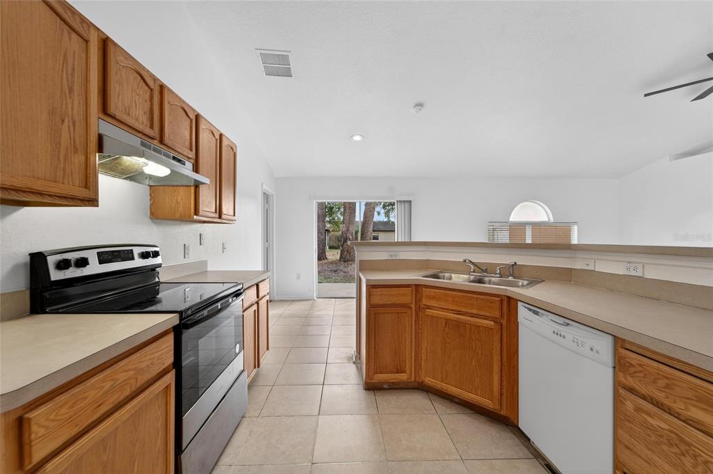 9010 Mc Cormick Street Spring Hill, FL 34608 - Photo 23 of 73 a kitchen with stainless steel appliances granite countertop a stove a sink and a refrigerator