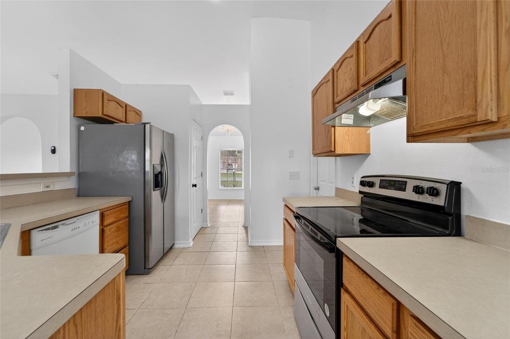 9010 Mc Cormick Street Spring Hill, FL 34608 - Photo 24 of 73 a kitchen with stainless steel appliances granite countertop a refrigerator and a stove
