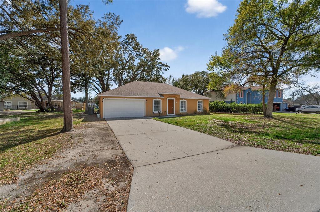 9010 Mc Cormick Street Spring Hill, FL 34608 - Photo 3 of 73 a front view of a house with a yard and garage