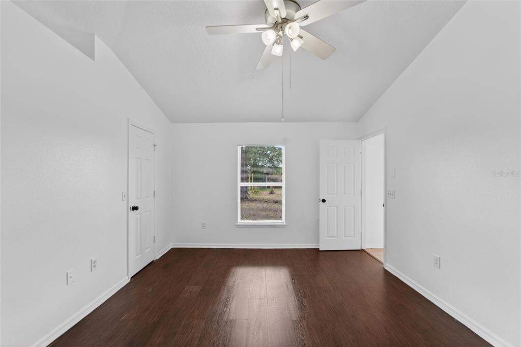 9010 Mc Cormick Street Spring Hill, FL 34608 - Photo 34 of 73 an empty room with wooden floor chandelier fan and windows