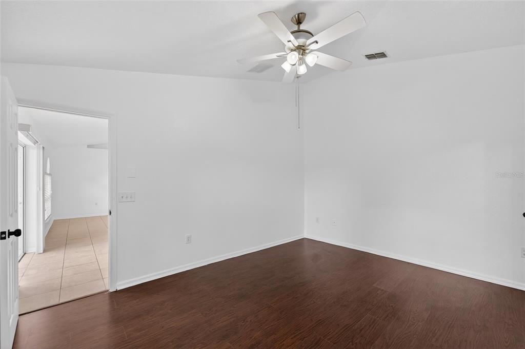 9010 Mc Cormick Street Spring Hill, FL 34608 - Photo 37 of 73 an empty room with a chandelier fan and wooden floor