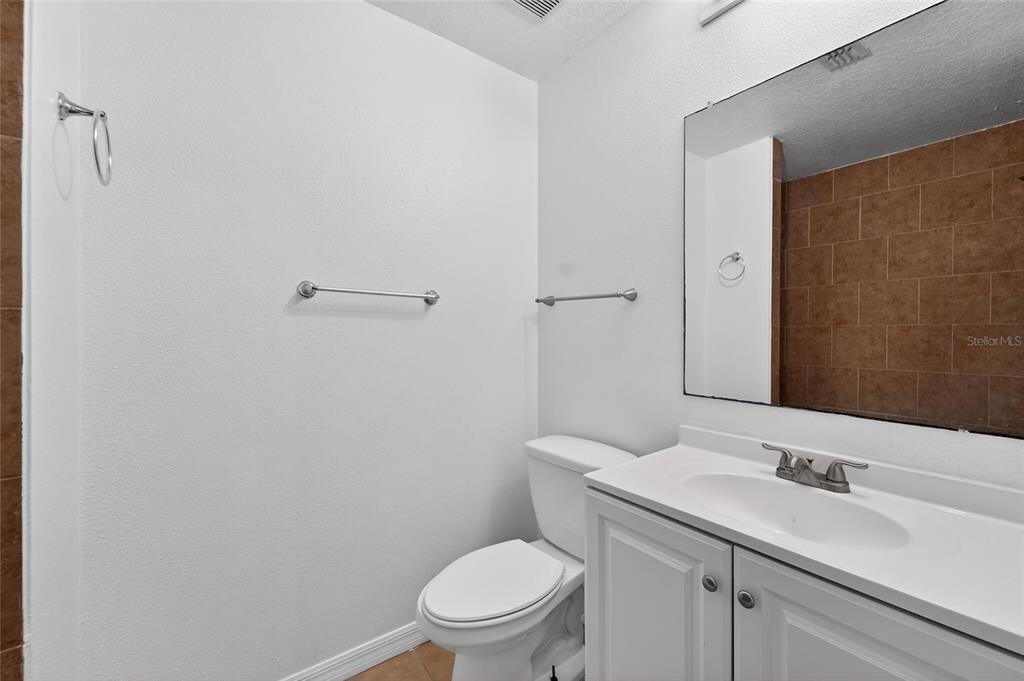 9010 Mc Cormick Street Spring Hill, FL 34608 - Photo 39 of 73 a bathroom with a toilet a sink a vanity and mirror