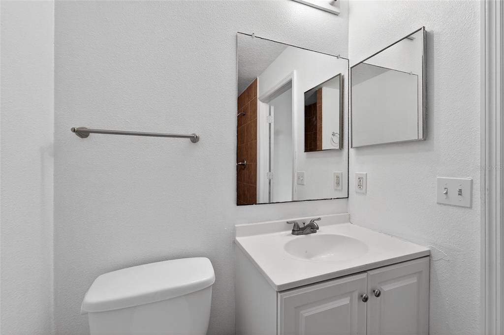 9010 Mc Cormick Street Spring Hill, FL 34608 - Photo 40 of 73 a bathroom with a toilet a sink and mirror