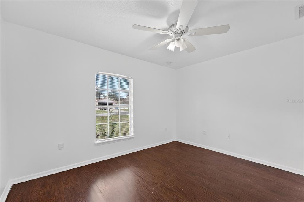 9010 Mc Cormick Street Spring Hill, FL 34608 - Photo 45 of 73 a view of an empty room with wooden floor and a window