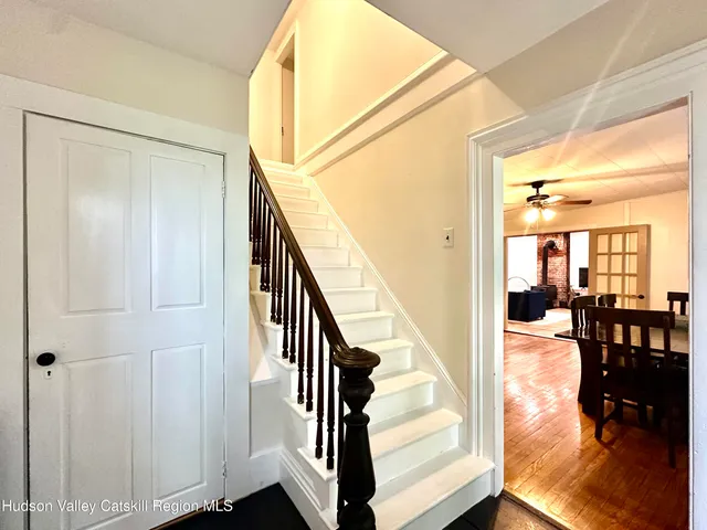 a view of a hallway with wooden floor staircase and livingroom view