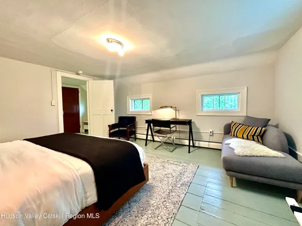 a spacious bedroom with a bed a couch and a window