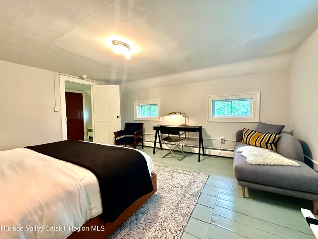 a spacious bedroom with a bed a couch and a window