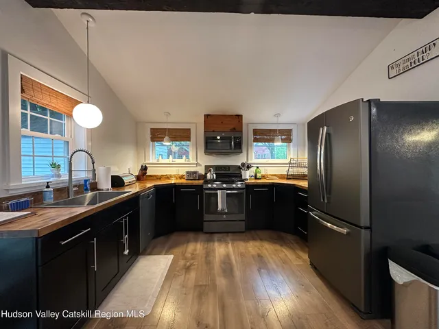 a kitchen with stainless steel appliances granite countertop a refrigerator a sink dishwasher a stove and a refrigerator