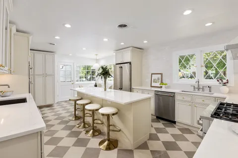 a kitchen with a stove a sink a refrigerator and cabinets