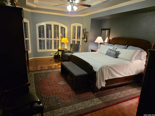 a bedroom with a bed window and chandelier