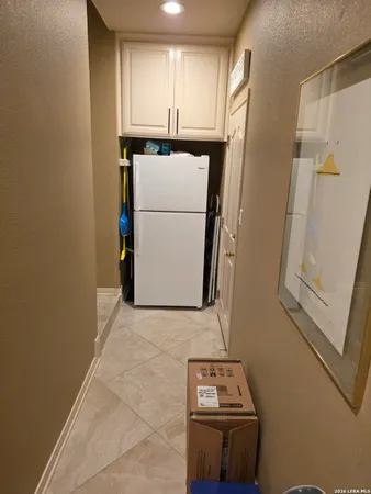 a living room with furniture a flat screen tv and a refrigerator