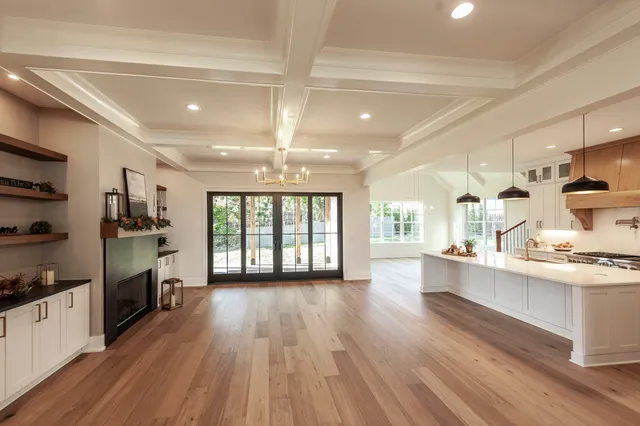 a view of a living room and kitchen with furniture and wooden floor