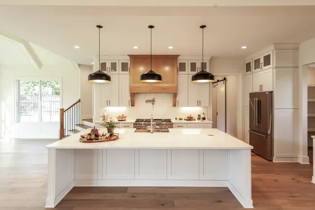 a spacious bathroom with a double vanity sink a large mirror and a bathtub