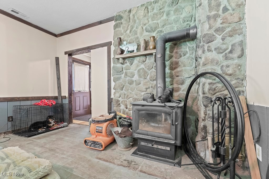 3271 Gorge Road Southwest Dellroy, OH 44620 - Photo 21 of 48 Living room featuring a wood stove and crown molding