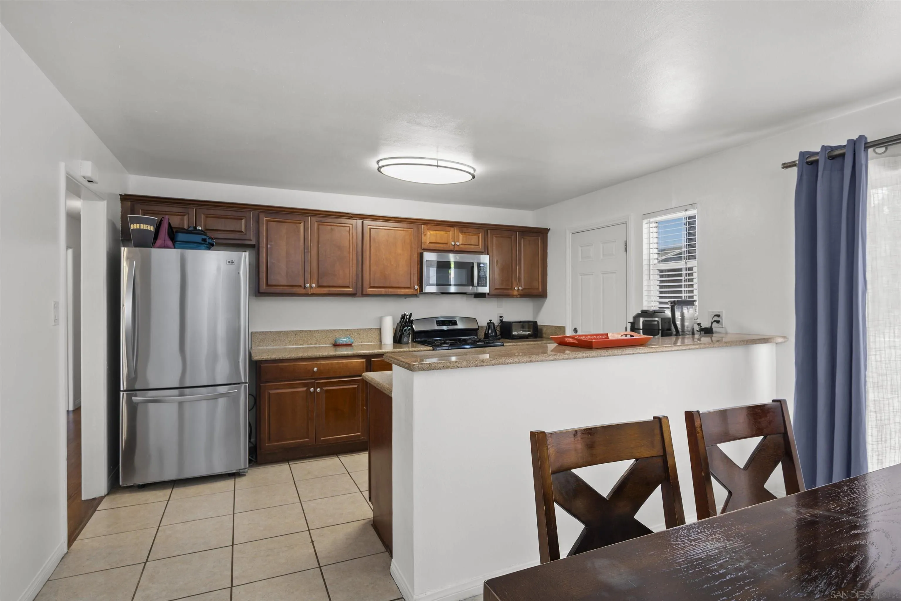 8740 Adriana Street Spring Valley, CA 91977 - Photo 11 of 32 a kitchen with stainless steel appliances granite countertop a refrigerator a stove top oven and a sink