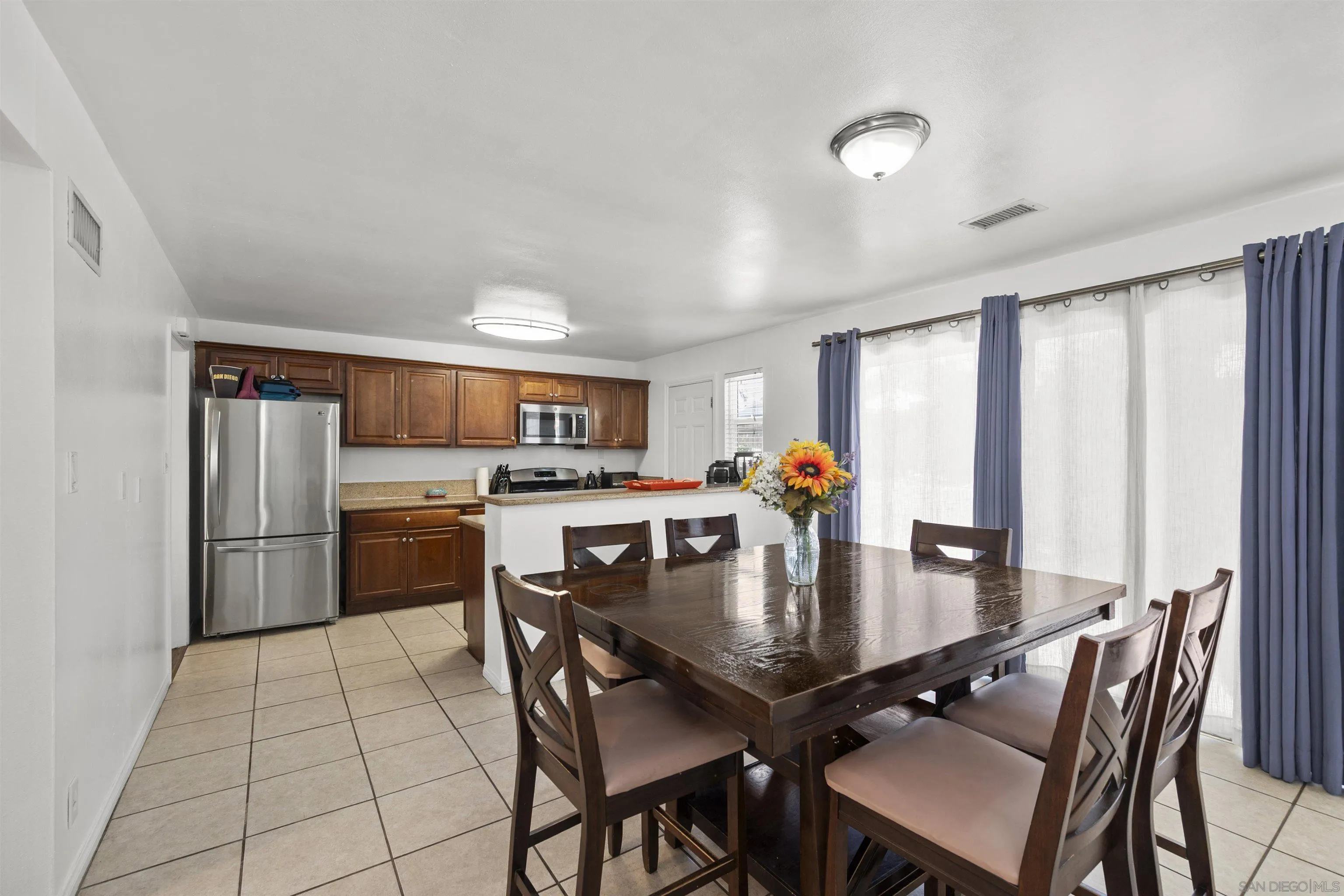 8740 Adriana Street Spring Valley, CA 91977 - Photo 13 of 32 a dining room with furniture and a kitchen view