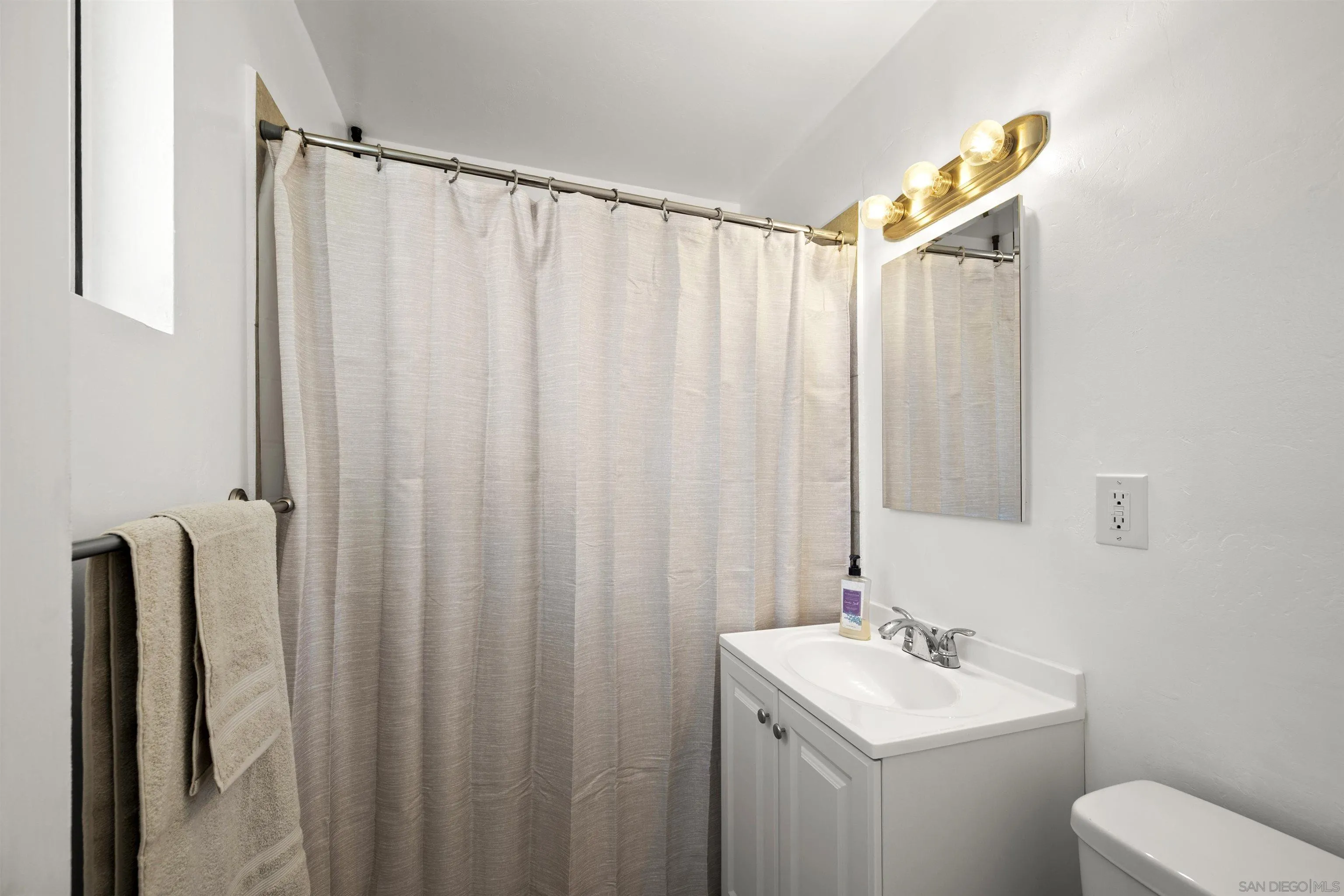 8740 Adriana Street Spring Valley, CA 91977 - Photo 20 of 32 a bathroom with a sink a toilet and a mirror