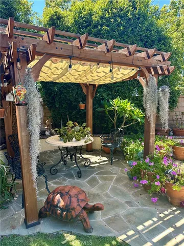 a view of a patio with table and chairs potted plants with wooden floor and fence