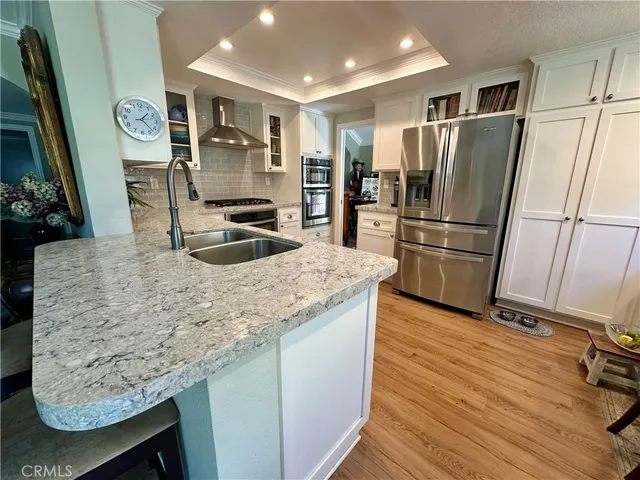 a kitchen with granite countertop a refrigerator and a sink