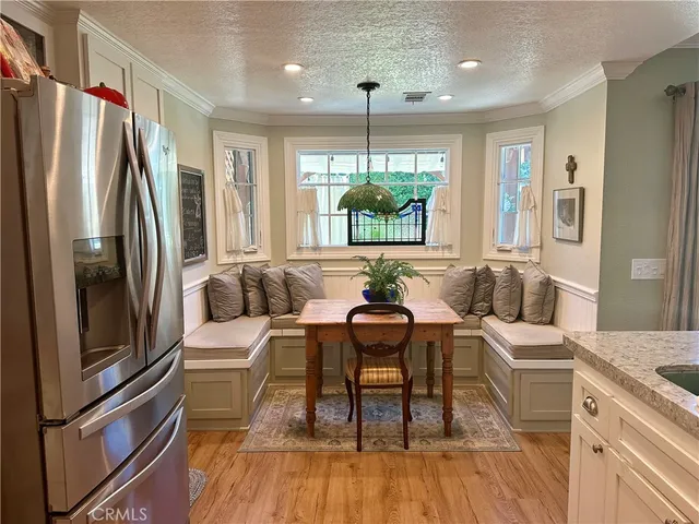 a living room with furniture a large window wooden floor and a chandelier