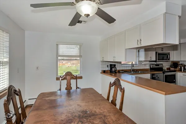 a kitchen with furniture a refrigerator and a stove top oven