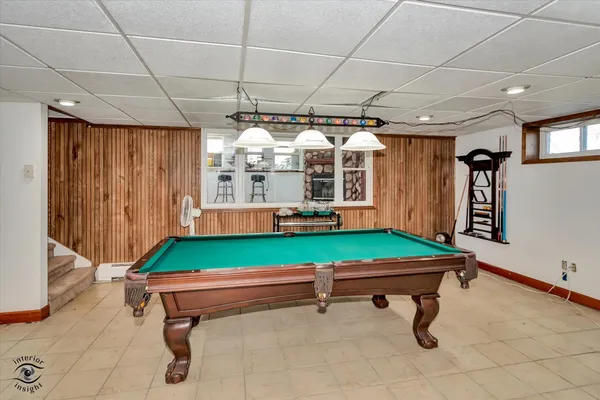 a room with pool table and windows