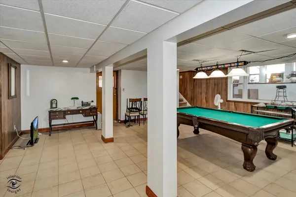 a room with pool table and windows
