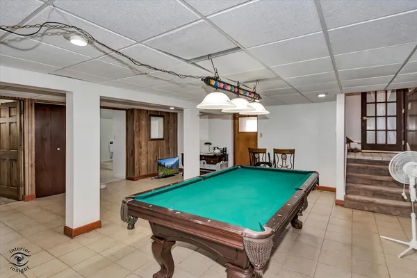 a room with pool table and windows