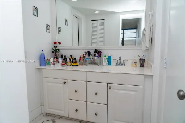 a bathroom with cabinets sink and a mirror