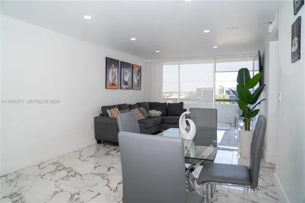 a living room with furniture a window and a potted plant