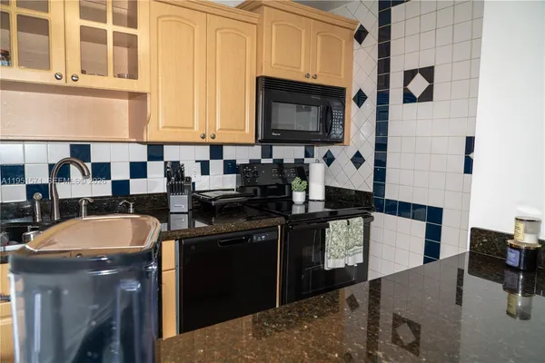 a kitchen with a sink a stove and cabinets