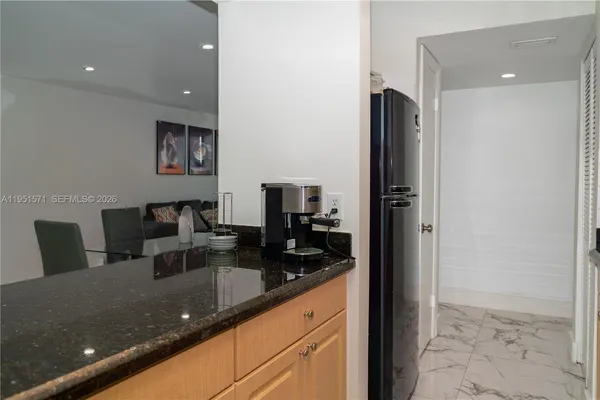 a kitchen with granite countertop a refrigerator and a sink