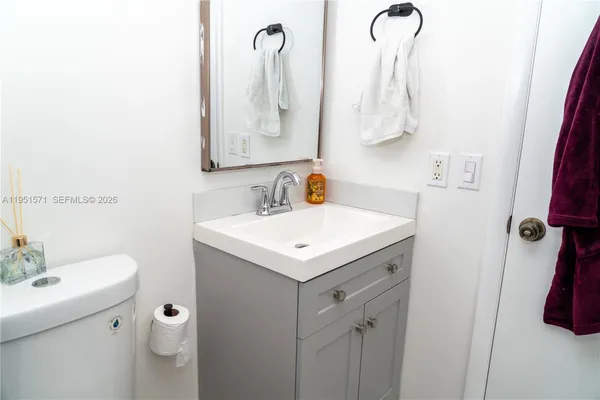 a bathroom with a sink and mirror with toilet