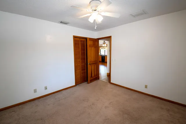 a view of an empty room with cabinet and door