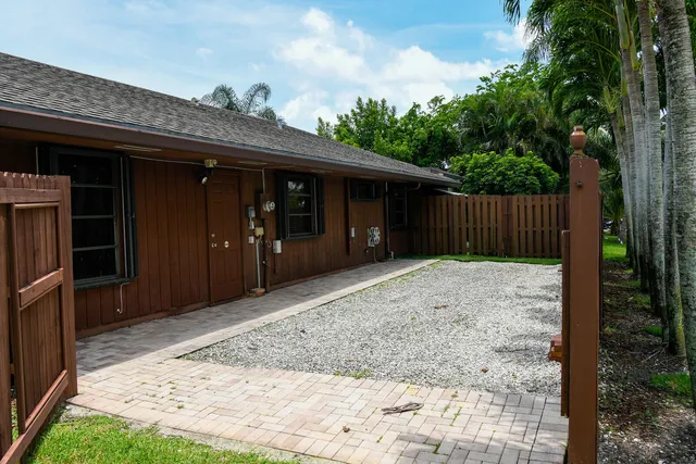 a view of backyard with potted plants and wooden fence
