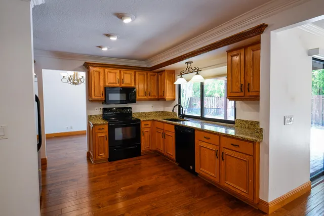 a kitchen with stainless steel appliances granite countertop a stove a sink and a refrigerator