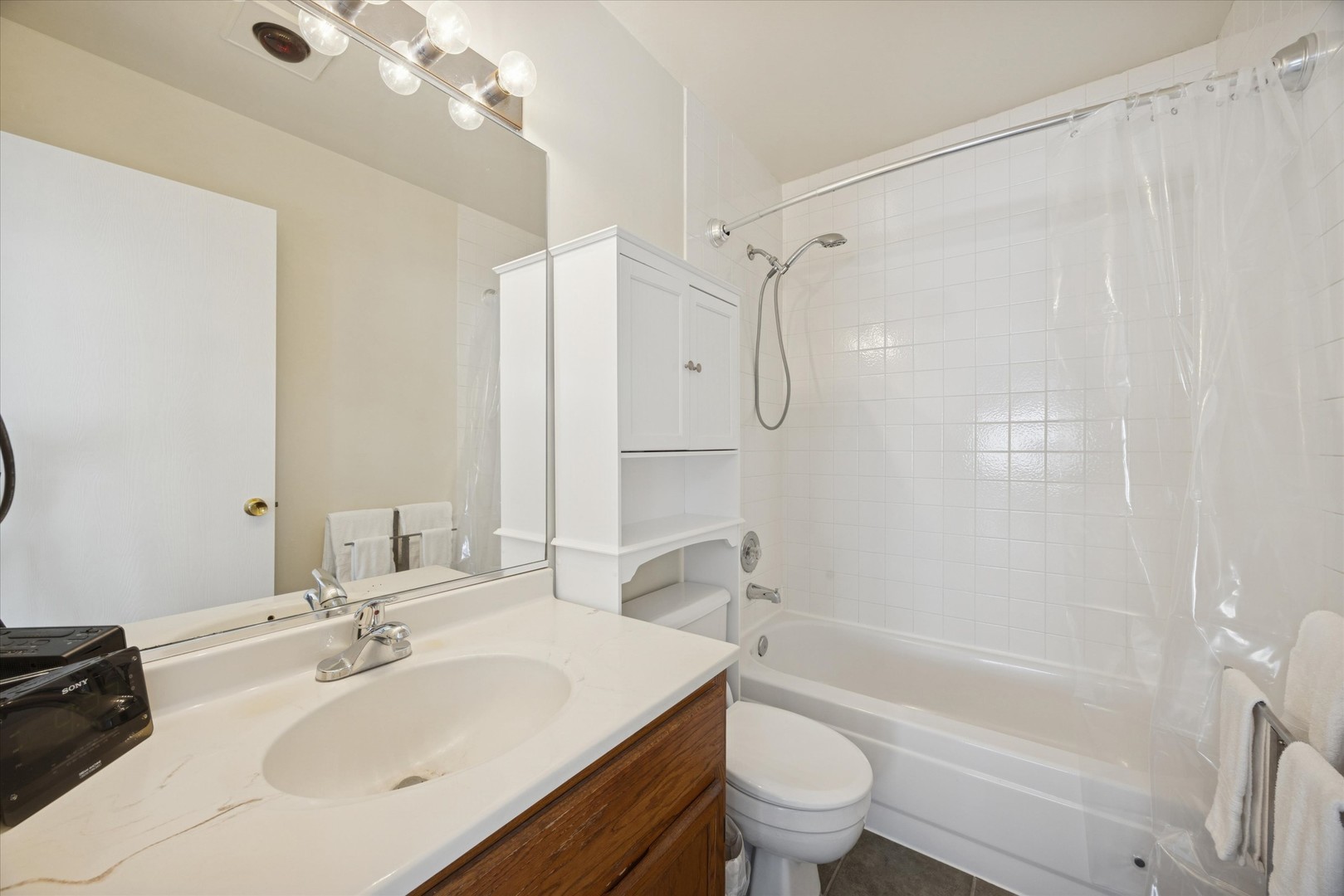 351 Park Ridge Lane, Unit D Aurora, IL 60504 - Photo 15 of 29 a bathroom with a sink a toilet and a large mirror
