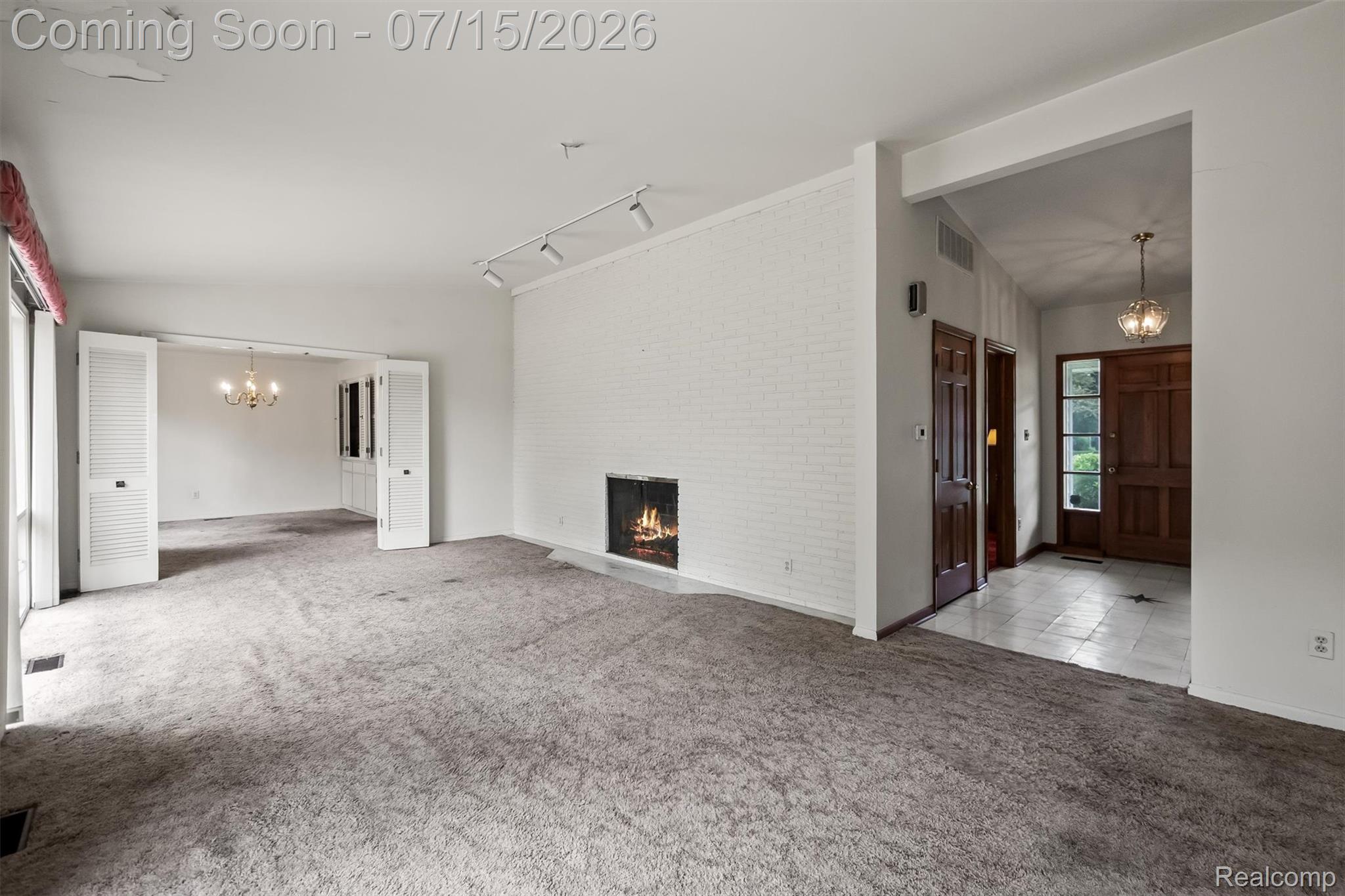 1151 Peveril Road Bloomfield Hills, MI 48304 - Photo 6 of 39 Spacious living area featuring a white, wood burning brick fireplace with track lighting