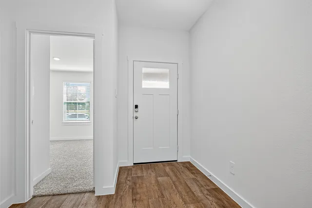 a view of a hallway with wooden floor