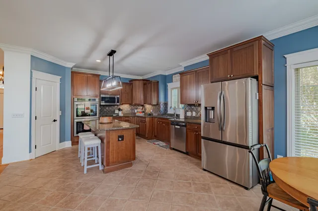 a kitchen with stainless steel appliances granite countertop a sink refrigerator and cabinets