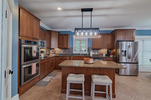 a open kitchen with stainless steel appliances granite countertop a stove and a refrigerator