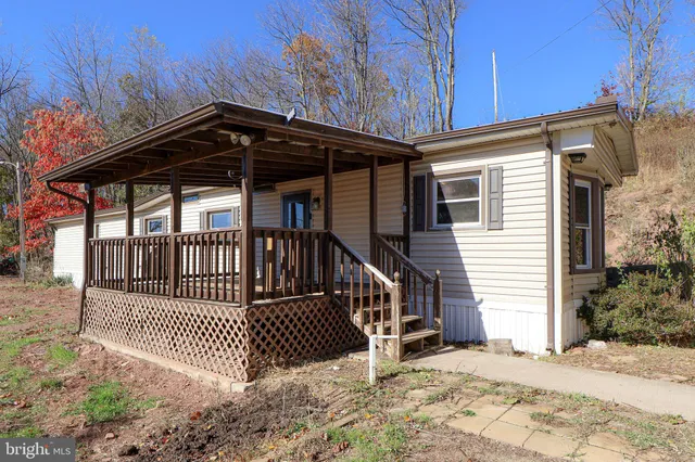 a view of a brick house with wooden fence and floor