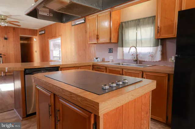a kitchen with stainless steel appliances granite countertop a sink a refrigerator and a stove
