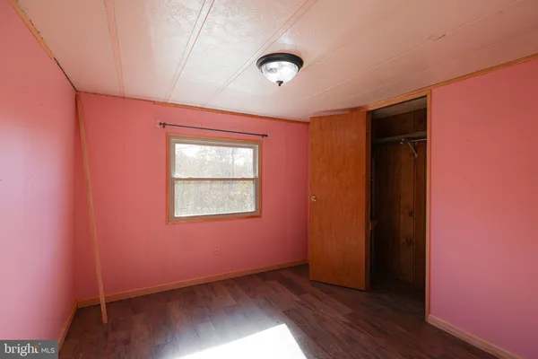 an empty room with wooden floor and closet