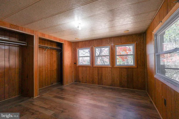 an empty room with wooden floor and closet