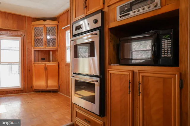a kitchen with stainless steel appliances granite countertop a sink a stove and a wooden floors
