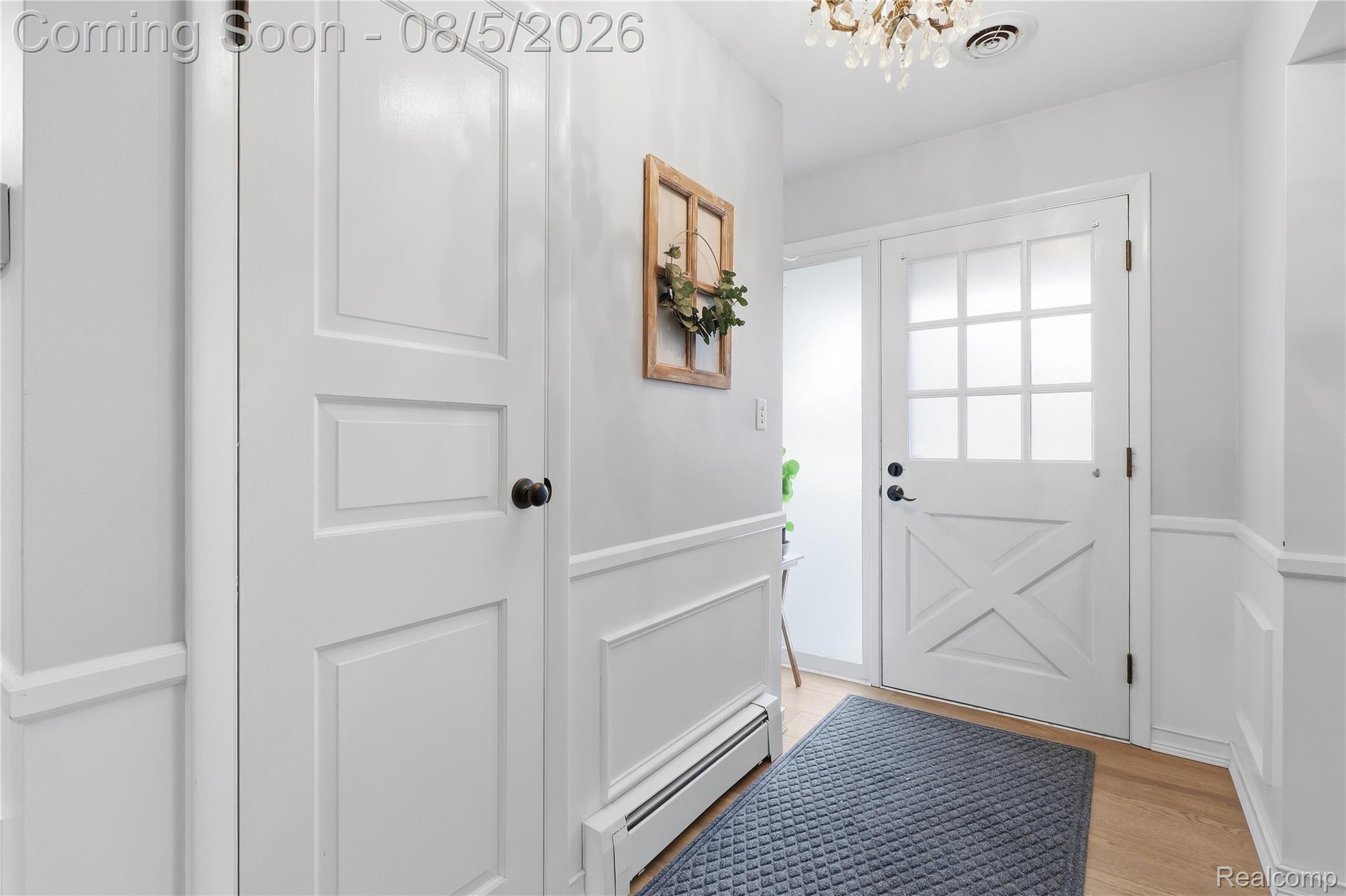 6478 West Stanley Road Mount Morris, MI 48458 - Photo 19 of 80 Entryway featuring a white barn-style door with frosted glass panes, light wood-finish flooring, and wainscoting